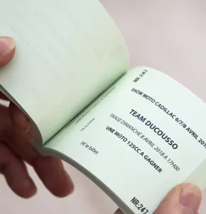 Boleto de rifa en forma de libro con impresión en negro