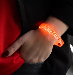 Orangefarbenes LED-Armband mit weißem Aufdruck